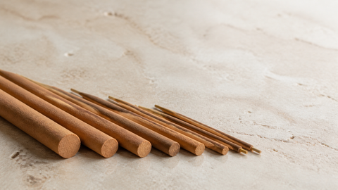 Incense sticks in different diameters arranged side by side on a neutral tabletop