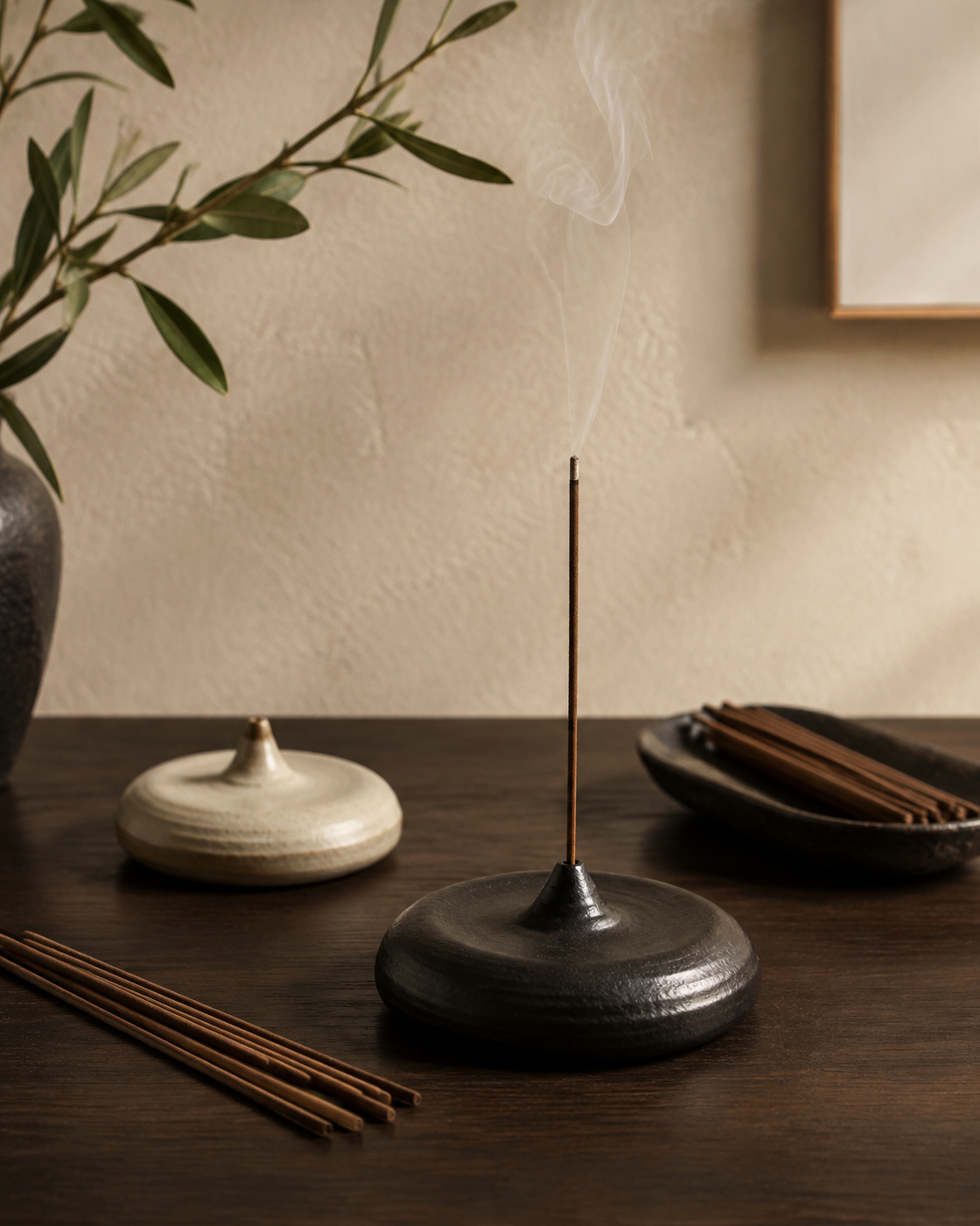 Ceramic incense holders and incense sticks on a warm wood table