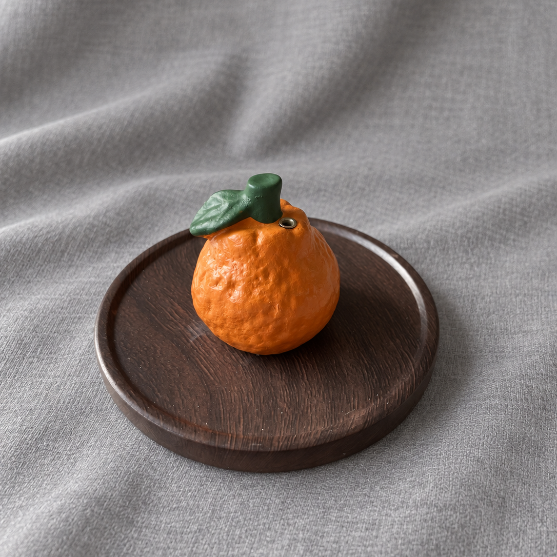 Mandarin orange incense holder with its brown wood-grain tray