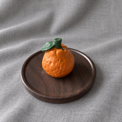 Mandarin orange incense holder with its brown wood-grain tray